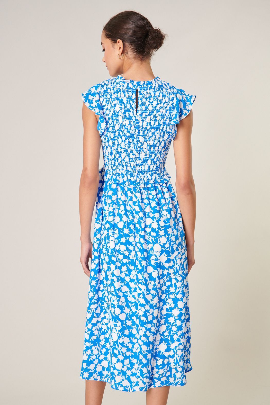 Back view of blue and white midi dress with smocked bodice and round neckline